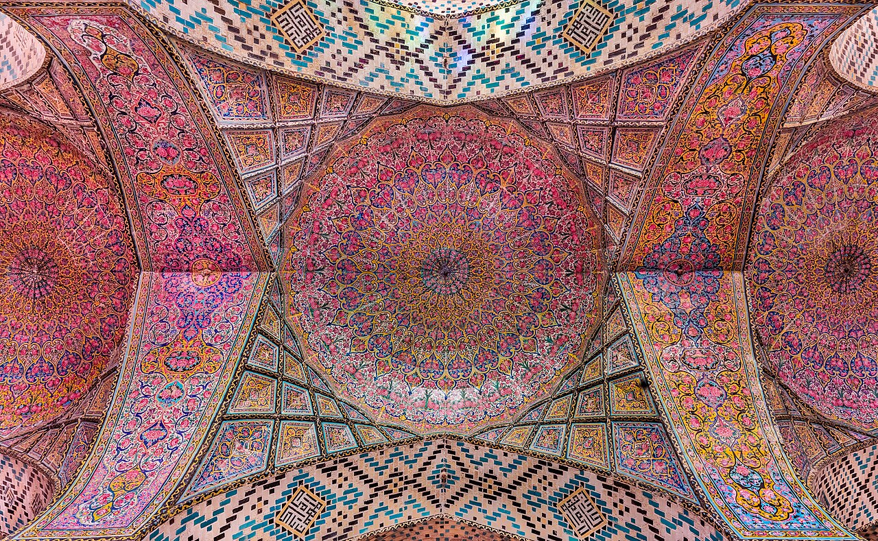 Witraże w Meczecie Nasir al-Mulk w Szirazie rzucające kolorowe światło na dywany.